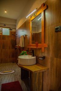 a bathroom with a sink and a mirror at Tunnel Top Inn Ella in Ella