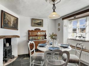 a dining room with a table and chairs and a fireplace at Captains Cottage Minehead in Minehead