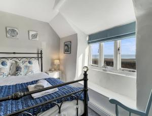 a bedroom with a bed and a window with the ocean at Captains Cottage Minehead in Minehead