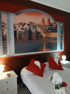 a bed with red pillows and a picture of a city at Regina Stella in Lascari +86 photos