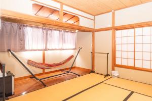 una habitación con una hamaca en la esquina de una habitación en ＳｅａＳａｉｄｅＨｏｕｓｅ湯河原, en Yugawara