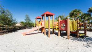 un parque infantil con un tobogán en la arena en Solterra Villa with Screened Pool & Lake View, en Loughman