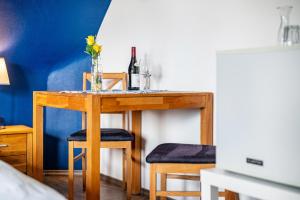 a table with a bottle of wine and two stools at Café Pension Pfaus Heidburg in Mühlenbach