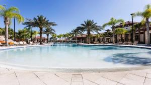 Una gran piscina en un complejo con palmeras. en Solterra Villa with Screened Pool & Lake View, en Loughman