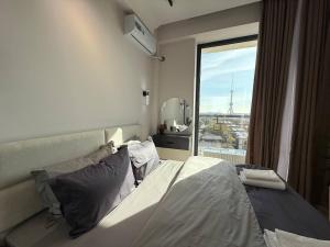 a bedroom with a bed and a large window at Modern spaces 12 in Yunusobod