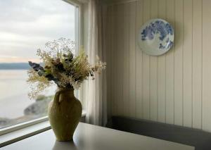 a vase with flowers sitting on a table near a window at Romantic Summer House On Orust in Stillingsön +33 photos