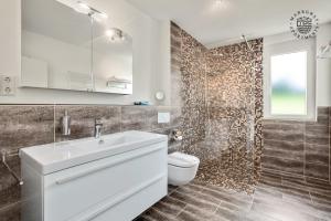 a bathroom with a white sink and a toilet at ! NEU ! Markgraf Premium Apartments - Bad Bellingen in Bad Bellingen +31 photos