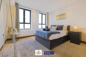 a bedroom with a bed and a couch in it at Spacious 2BR, 2BA Apt By Nativa Homes Short Lets & Serviced Accommodation Harrow With Fast WiFi, Kitchen in Harrow