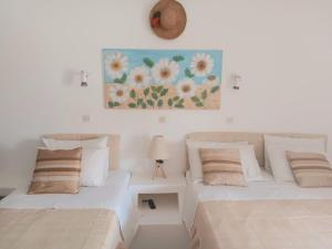 a bedroom with two beds and a painting on the wall at Villa Rena in Batsi +179 photos