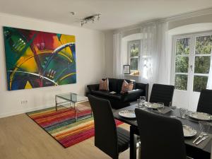 a living room with a table and a painting on the wall at Ferienwohnung Kity mit Terrasse und Bergblick in Grainau