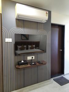a wall with a shelf in a room with a bed at Hotel The Golden Oaks, Kolhapur in Kolhapur