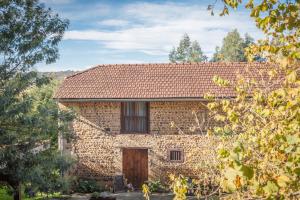 een oud stenen huis met een bruin dak bij Gites les Renardiers in Clarac
