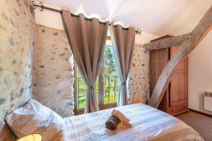 een slaapkamer met een bed en een raam bij Gites les Renardiers in Clarac