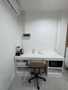 a white desk with a chair in a room at Palai House in Ban Na Bon