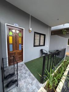 a front door of a house with a green rug at Palai House in Ban Na Bon