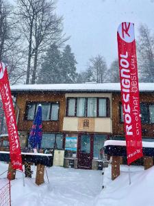 two signs in the snow in front of a building at Finish Line Guest House in Borovets