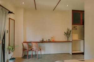 a kitchen with two chairs and a counter at UNLTD Hotel Siargao in General Luna