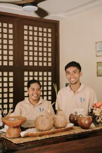 twee mannen naast een tafel met eten bij UNLTD Hotel Siargao in General Luna