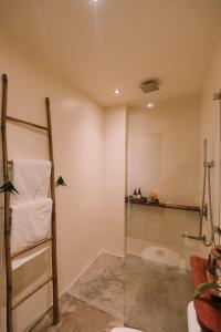 een badkamer met een ladder en handdoeken aan de muur bij UNLTD Hotel Siargao in General Luna