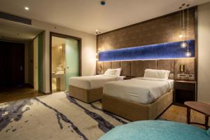 une chambre d'hôtel avec deux lits et un mur bleu dans l'établissement Hotel Lumbini Heritage, à Rummindei