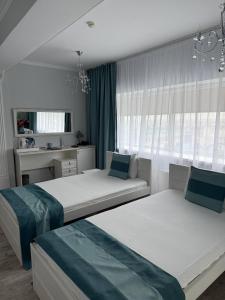a bedroom with two beds and a window at Vip House Hotel in Astana