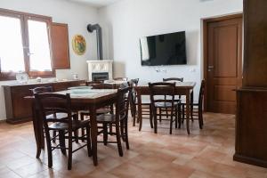ein Esszimmer mit Tisch und Stühlen und einem Fernseher in der Unterkunft B&B 4 Stagioni in Dattilo