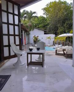 a patio with a table and chairs and an umbrella at Pousada Solar de Maria e Hostel in Baixa de São Francisco