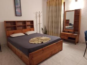a bedroom with a wooden bed with a mirror at Urenium Matara in Matara