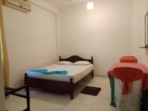 a small bedroom with a bed and a table at Urenium Matara in Matara