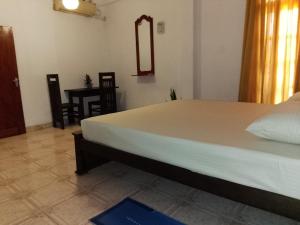 a bedroom with a bed and a mirror and a table at Urenium Matara in Matara