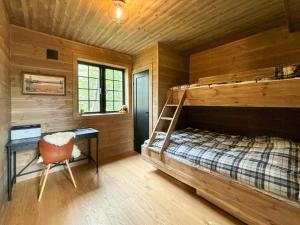 a bedroom with a bunk bed and a desk in a cabin at Mountain Cabin With Views Over Jämtland's Expanse in Storhågna