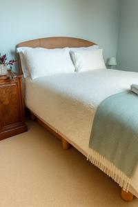 een slaapkamer met een bed en een houten nachtkastje bij Beachy Days and Family Stays in Nairn