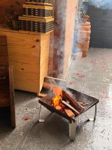 a grill with fire in the middle of a room at Suíte Rustica Aconchego - Com Banheira de Hidromassagem in Campos do Jordão