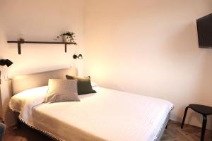 a bedroom with a bed with white sheets at B&B Casa Valentina in Rome