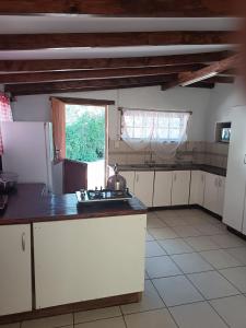a kitchen with white cabinets and a large window at Anker Guesthouse in Philippolis