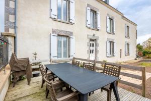 a blue table and chairs on a wooden deck at Gîte de L'Ouvroux-25min Puy Du Fou in Montournais