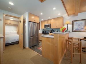 uma cozinha com um frigorífico e uma cama num quarto em RMR: La Choumine 4 Condo in Teton Village em Teton Village mais 9 fotografias