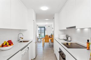 een witte keuken met een fruitschaal op het aanrecht bij MEDANO4YOU The Surf Backyard in El Médano