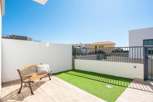 een balkon met een bank en een groen gazon bij MEDANO4YOU The Surf Backyard in El Médano +33 foto's
