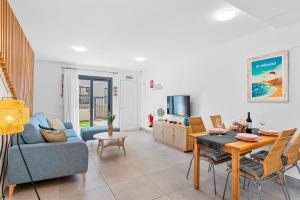 een woonkamer met een blauwe bank en een tafel bij MEDANO4YOU The Surf Backyard in El Médano