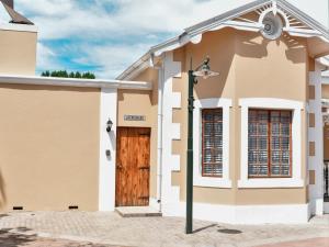a house with a wooden door and a street light at Splendid Village in Beaufort West