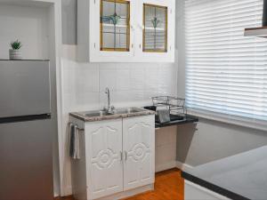 a white kitchen with a sink and a refrigerator at Splendid Village in Beaufort West +5 photos