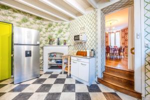 a kitchen with a refrigerator and a table at Gîte de L'Ouvroux-25min Puy Du Fou in Montournais