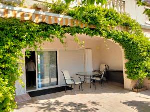 a patio with a table and chairs under an arch at casa Palm Beach in Montroig