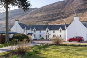 a house with a red car parked in front of it at Hartfield House Hostel in Applecross