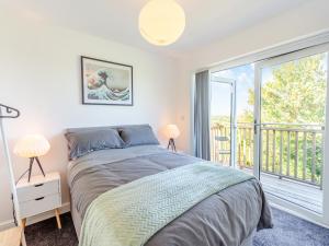 een slaapkamer met een bed en een groot raam bij Willow House in Worle