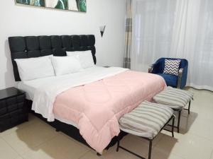 een slaapkamer met een groot bed en twee stoelen bij Le Ptit Zinc in Kigali