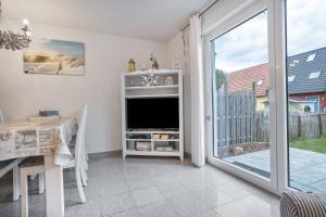 a living room with a tv and a sliding glass door at Ostsee in Pruchten