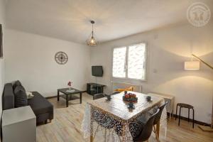 a living room with a table and a couch at Le sorberan in Sorbiers