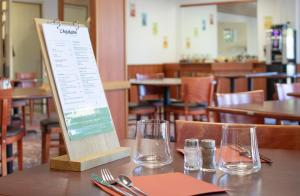 een bord op een tafel in een restaurant bij Brit Hotel Agen - L'Aquitaine in Le Passage